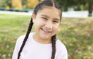Young girl with braids standing outside