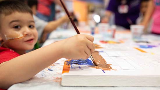 A MWPH patient makes ceiling tile artwork as part of an evening activity. 